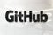 Github on glossy office wall realistic texture