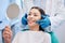 Give me your biggest smile. a young woman checking her results in the dentists office.