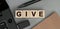 Give - word concept from wooden blocks. Top view