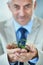 Give your business the life it deserves. a mature businessman holding a small plant growing in soil.