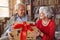 Giving Christmas gift on celebration time- senior man with presents spending Christmas together with woman.