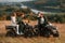 Giving high five and smiling. Two young couples with quad bikes is together on the field