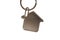 Giving house key with a key chain house shape