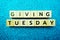 Giving Tuesday alphabet letter on blue glitter background