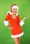 Giving your brand some Christmas cheer. Attractive woman in a Christmas costume pointing to something interesting -