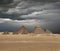 The Giza pyramid complex under dramatic grey stormy sky