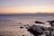 Glacier carved coastal rocks on the calm ocean moments before sunrise