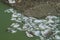 Glacier cracks covered with gray rocks, icebergs in a lake