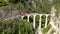 Glacier Express train on Landwasser viaduct in the Swiss Alps