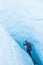 Glacier ice climbing guide walking through narrow sloping canyon on the Matanuska Glacier in Alaska