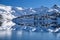 Glacier reflection in half frozen alpine lake. Beautiful blue Garibaldi lake in winter.