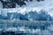 Glacier wall in Antarctica, majestic blue and white glacier edge with small Zodiac in front, Paradise Bay, Antarctica