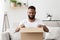 Glad african american millennial guy opens big box