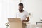 Glad african american millennial man opens box