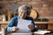 Glad aged latin lady read paper letter with good news