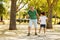 Glad black little boy and man with beard play, rest in park, run competition outdoor