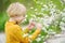 Glad boy admiring blossom cherry tree in sunny garden