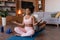 Glad calm young african american couple in sportswear with closed eyes meditation, practice yoga on mat