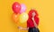 glad child in crown with helium balloon on yellow background