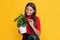 glad child with monstera in pot on yellow background