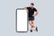 Glad confident young caucasian guy athlete in sportswear, near smartphone with empty screen