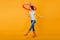 Glad curly girl in jeans funny dancing holding trendy parasol. Studio portrait of inspired young woman in rubber shoes