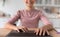 Glad cute european teenage girl typing on laptop keyboard in kitchen interior, blurred