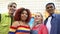 Glad group of multiracial teenagers in colorful trendy clothes smiling camera
