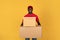 Glad handsome millennial black guy courier in red uniform hold many big boxes for delivery