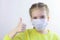 Glad and happy beautiful joy,child in the medical helthcare guarding or protecting mask and in yellow t-shirt