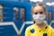 Glad and happy beautiful joy child in the medical helthcare guarding or protecting mask and in yellow t-shirt in the tube, subway