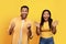 Glad millennial african american husband and wife celebrating victory, making success sign with hands