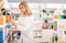 Glad pharmacist is browsing rows of products