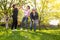 Glad, positive smiling family playing French traditional game petanque in the garden outside during lovely summer day