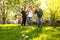 Glad, positive smiling family playing French traditional game petanque in the garden outside during lovely summer day