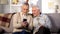 Glad senior friends watching online video by smartphone application, gadget