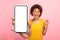Glad surprised young african american curly lady show smartphone with blank screen, make victory