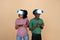 Glad surprised young black family with belly, in VR glasses play online game with joysticks
