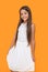 glad teen girl in white dress on yellow background