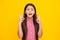 Glad teenager girl crosses fingers, closes eyes with pleasure, anticipate hearing good news,  yellow background