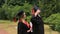 Glad woman and man in academic dresses embracing after graduation ceremony