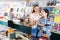 Glad woman showing open book to happy girl in book boutique