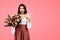 Glad young caucasian lady in casual with open mouth, show finger at herself, hold bouquet of flowers