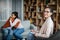 Glad young caucasian male hugging black female at meeting with doctor psychologist in office