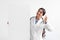 Glad young cute indian lady doctor in uniform shows ok sign with hand holds big banner with blank space