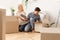 Gladful Couple Unpacking Boxes After Moving Into New Apartment