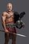 Gladiator in lightweight historical armor against grey studio background