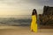 Glamorous African American black woman in chic and elegant summer dress posing relaxed walking on summer sunset beach