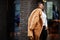 Glamorous african american woman in warm fur coat, eyeglasses pose at street