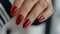 Glamorous close up of woman s hand with vibrant red nail polish on perfectly manicured fingernails